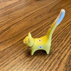 Vintage yellow cat ring holder with white and red flowers.